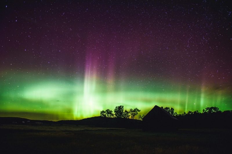 The northern lights emit a green glow in a dark sky.